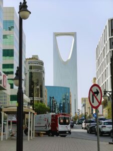 View of Kingdom Centre tower in Riyadh cityscape with nearby buildings and street