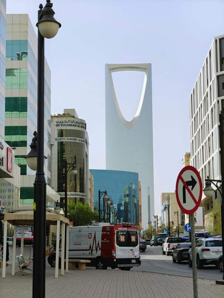 View of Kingdom Centre tower in Riyadh cityscape with nearby buildings and street