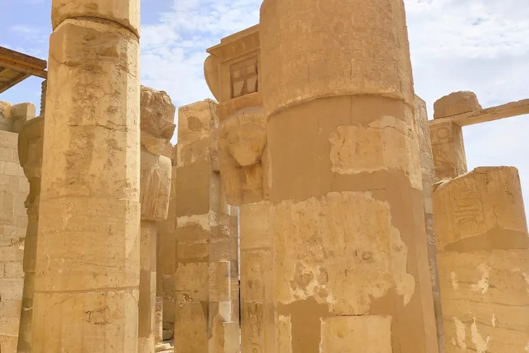 Massive ancient stone columns in a Luxor temple under a blue sky.