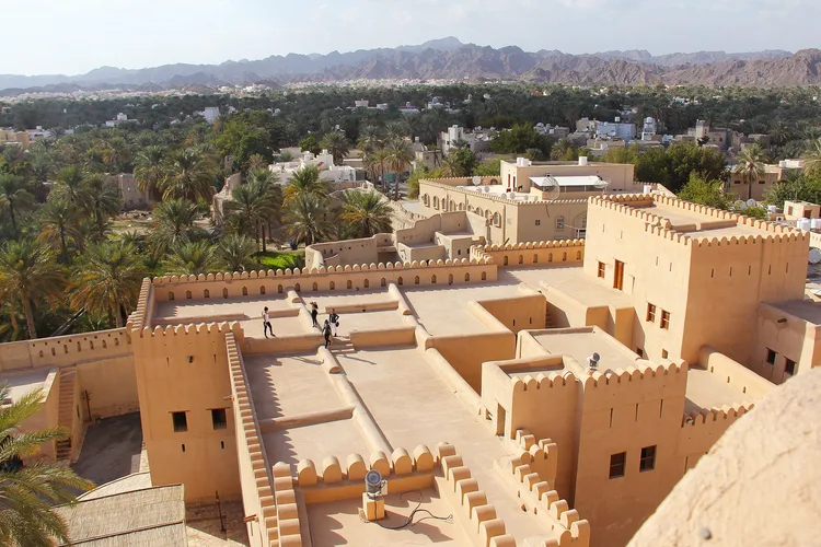 Aerial view of Bahla Fort with surrounding palm groves in Oman.