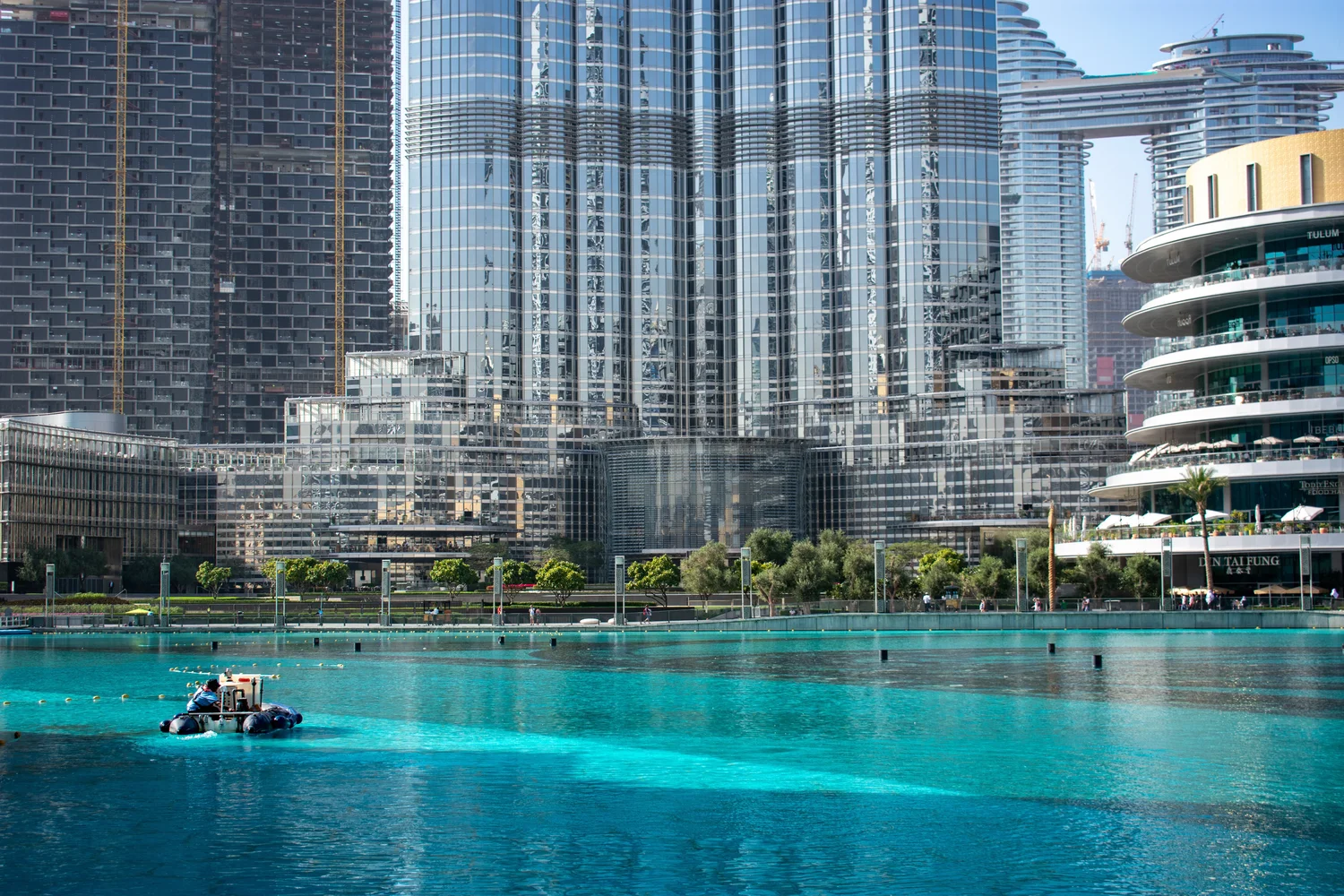 View of the Dubai skyline with Burj Khalifa and a nearby water feature.