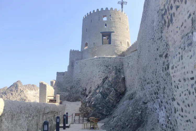 Historic stone structure of Mirani Fortress in Muscat, Oman, under clear sky.