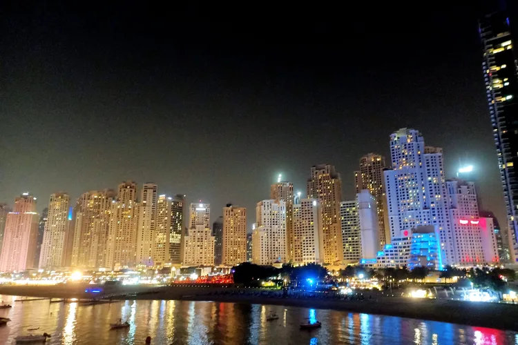 Night view of Dubai Marina skyline with illuminated skyscrapers.