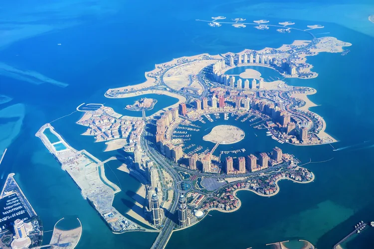 Aerial view of The Pearl-Qatar with a cluster of buildings and water.