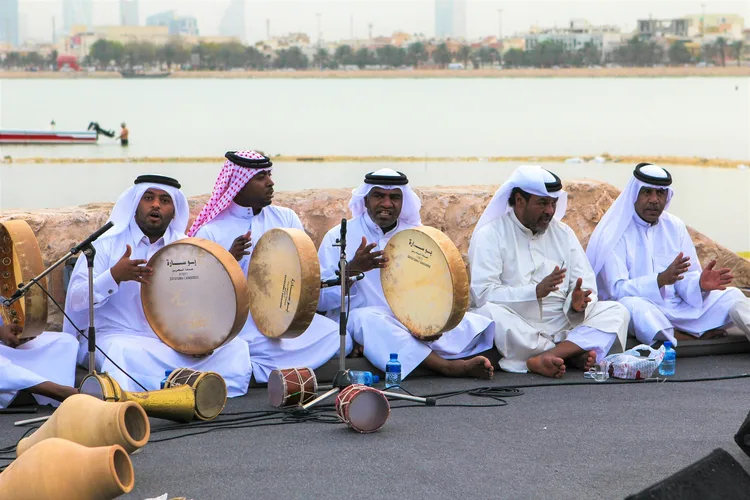 Traditional Bahraini musicians playing drums by the waterfront.