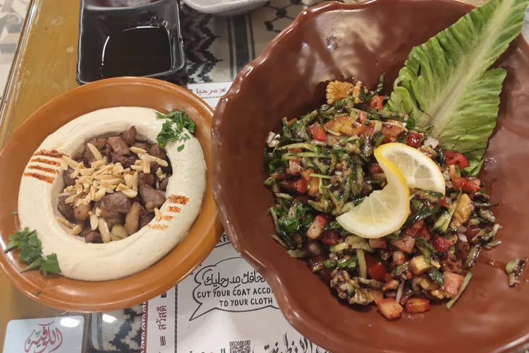 Two Arabic dishes including hummus and salad at AlKofeia in Riyadh.