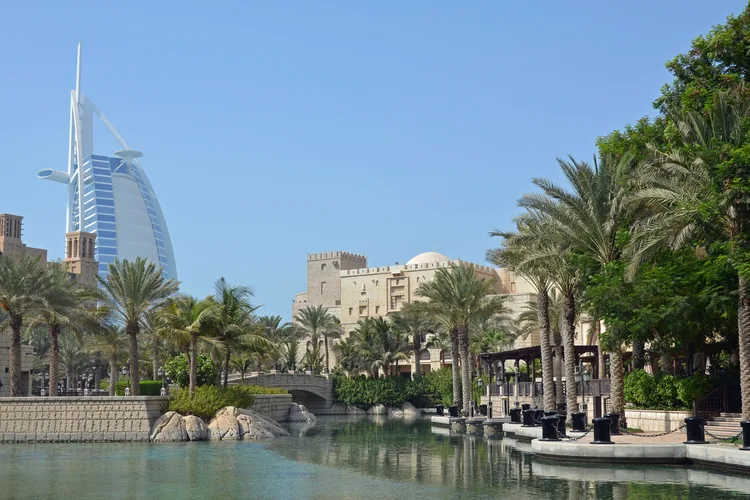 Burj Al Arab with canal and palm trees in Dubai.