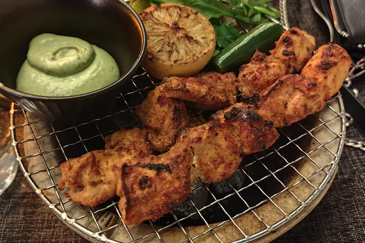 Grilled chicken skewers with sauce and lemon at Lusin Restaurant.