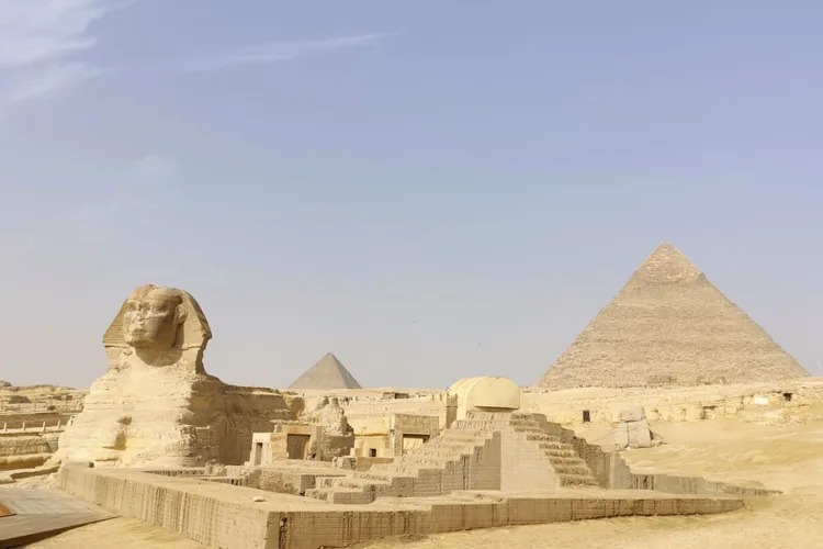 The Great Sphinx and pyramids under a clear sky in Giza, Egypt.